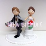 Bonecos do bolo de casamento com a noiva puxando pela gravata e noivo com cartas de baralho
