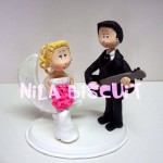 Bonecos do bolo de casamento com noivo tocando pra noiva