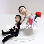 Bonequinhos do bolo de casamento com a noivinha segurando sacolas de compras