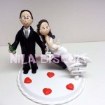 Bonequinhos do bolo de casamento noivos prontos para lua de mel ele levando champanhe e ela as taças