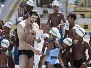 Phelps nada ao lado de crianças da Rocinha