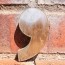 A metal comma on a brick background.