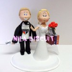 Bonecos do bolo de casamento com a noiva puxando pela gravata e noivo são paulino