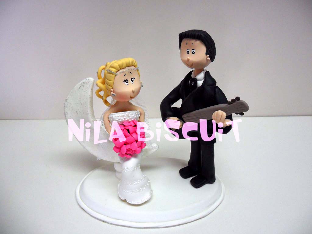 Bonecos do bolo de casamento com noivo tocando pra noiva
