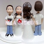Bonequinhos do bolo de casamento com a noiva com a mão na bunda do noivo