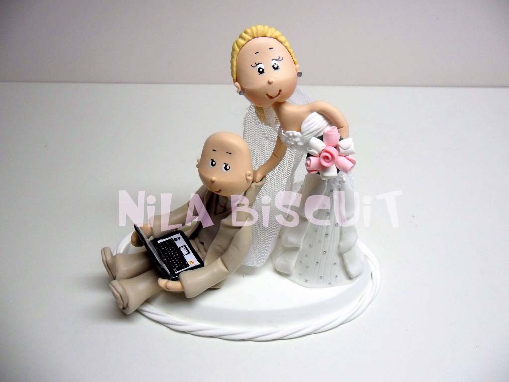 Bonequinhos do bolo de casamento com a noiva puxando noivo pelo colarinho