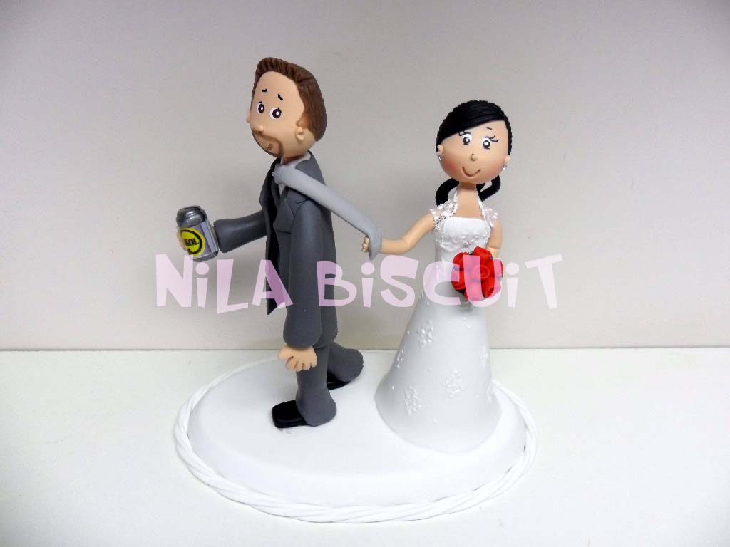 Bonequinhos  do bolo de casamento com a noiva puxando pela gravata