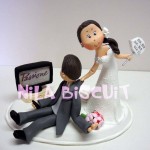 Bonequinhos do bolo de casamento com noivoassistindo novela e noiva puxando ele