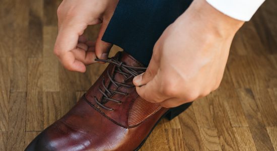 Calçado masculino para casamento: o que usar? | Foto de homem amarrando sapato social | CNS