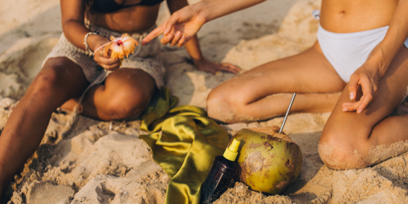 Desvendando a tanga maxi | Duas mulheres de biquíni sentadas na praia | Cia Marítima