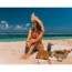 Dicas de modelos de biquínis elegantes | Mulher de biquíni sentada na areia da praia | Água Doce